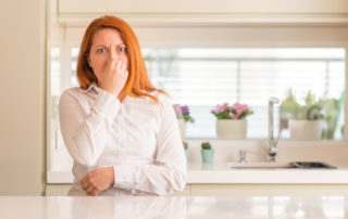 a woman holding her nose in disgust