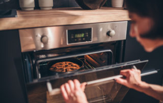 a woman opening an oven
