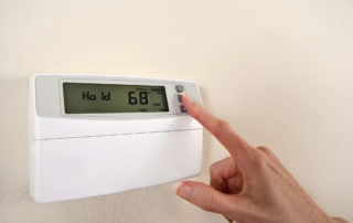 a finger touching a thermostat