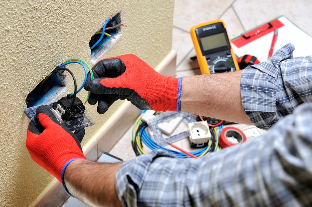 a man servicing some electrical wires|a man servicing some electrical wires